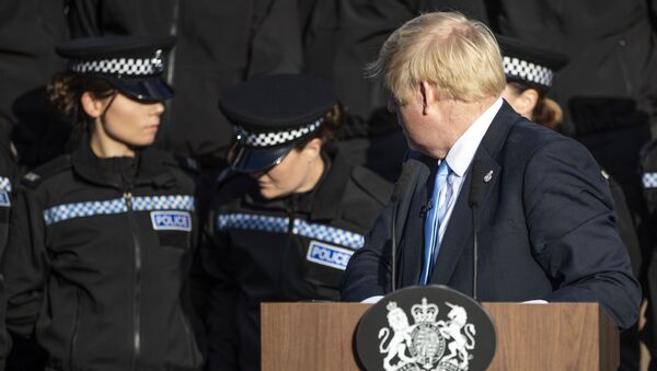 Britain's Prime Minister Boris Johnson (R) reacts as a student police officer appears to feel unwell as she stands behind the prime minister as he takes questions from members of the media during a visit with the police in West Yorkshire, northern England, on September 5, 2019 - Sputnik International