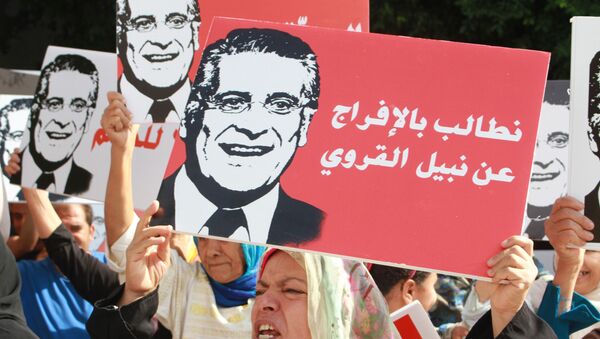 Supporters of presidential candidate Nabil Karoui carry placards with his image and slogans in his favour as they rally in front of the tribunal in the Tunisian capital Tunis asking for his release from prison on September 3, 2019. - Sputnik International