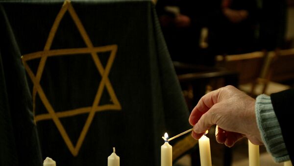 A person lights a candle during a ceremony in a synagogue - Sputnik International