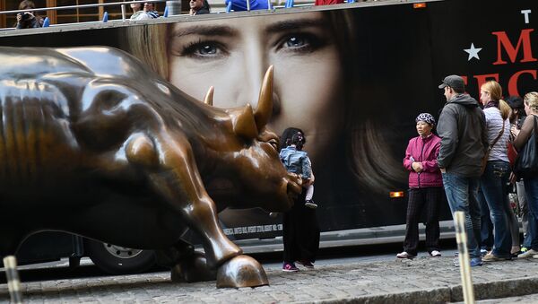 Tourists have their picture taken with the Charging Bull, which is sometimes referred to as the Wall Street Bull, in New York on October 17, 2014. - Sputnik International