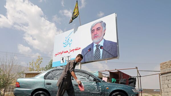 An Afghan boy washes a car near a poster of Afghanistan presidential candidate Abdullah Abdullah, in Kabul, Afghanistan September 8, 2019.  - Sputnik International