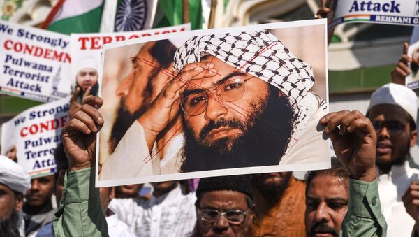 Indian Muslims hold a scratched photo of Jaish-e-Mohammad group chief, Maulana Masood Azhar, as they shout slogans against Pakistan during a protest in Mumbai on February 15, 2019 - Sputnik International
