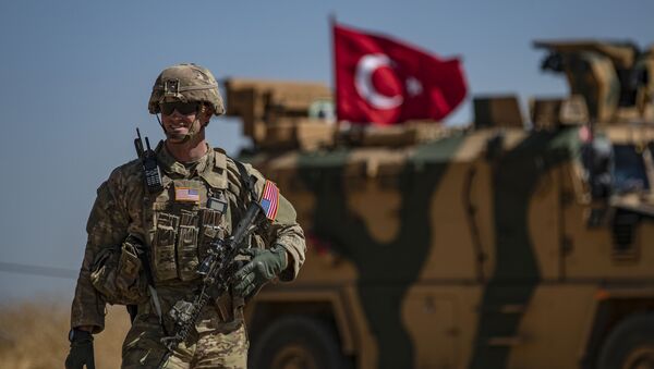 A US soldier stands guard during a joint patrol with Turkish troops in the Syrian village of al-Hashisha on the outskirts of Tal Abyad town along the border with Turkey, on September 8, 2019. - Sputnik International