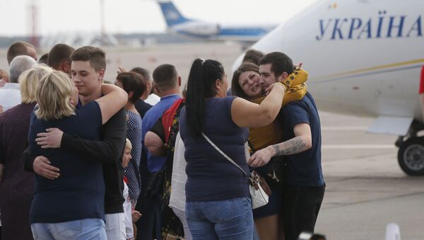 Relatives of Ukrainian prisoners freed by Russia greet them upon their arrival at Boryspil airport, outside Kyiv, Ukraine, Saturday, Sept. 7, 2019. Planes carrying prisoners freed by Russia and Ukraine have landed in the countries' capitals, in an exchange that could be a significant step toward improving relations between Moscow and Kyiv. The planes, each reportedly carrying 35 prisoners, landed almost simultaneously at Vnukovo airport in Moscow and at Kyiv's Boryspil airport. (AP Photo/Efrem Lukatsky) - Sputnik International