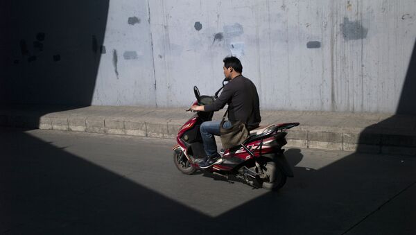 A man rides his electric scooter close to the fourth ring road in Beijing on April 20, 2016 - Sputnik International