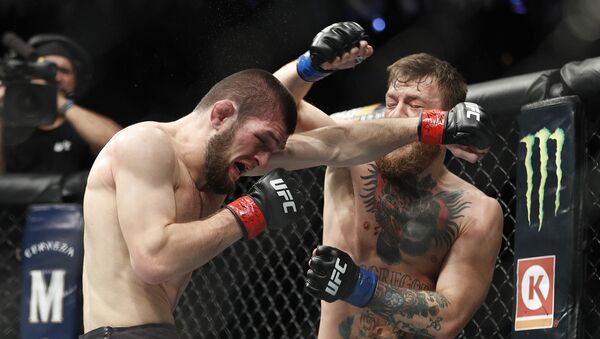 Khabib Nurmagomedov, left, and Conor McGregor throw punches during a lightweight title mixed martial arts bout at UFC 229 in Las Vegas, Saturday, Oct. 6, 2018 - Sputnik International