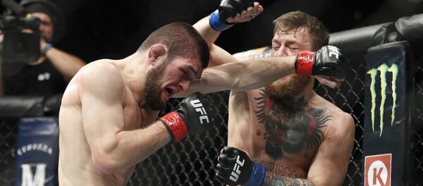 Khabib Nurmagomedov, left, and Conor McGregor throw punches during a lightweight title mixed martial arts bout at UFC 229 in Las Vegas, Saturday, Oct. 6, 2018 - Sputnik International