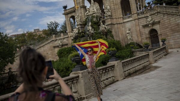 A tourist poses for a snapshot with a Catalan independence flag during the Catalan National Day in Barcelona, Spain, Wednesday, Sept. 11, 2019. The traditional September 11, called Diada, marks the fall of Barcelona to Spanish forces in 1714.  - Sputnik International