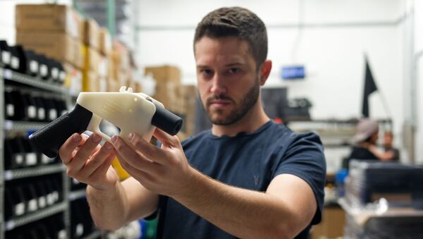 Cody Wilson, owner of Defense Distributed company, holds a 3D printed gun, called the Liberator, in his factory in Austin, Texas on August 1, 2018 - Sputnik International