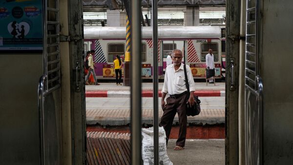 A man waits for a train at a railway station in Mumbai. - Sputnik International