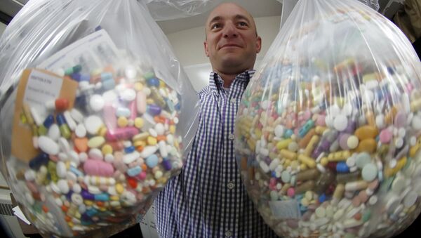 Narcotics detective Ben Hill, with the Barberton Police Department, shows two bags of medications that are are stored in their headquarters and slated for destruction, Wednesday, Sept. 11, 2019, in Barberton, Ohio. Attorneys representing some 2,000 local governments said Wednesday they have agreed to a tentative settlement with OxyContin maker Purdue Pharma over the toll of the nation's opioid crisis. (AP Photo/Keith Srakocic) - Sputnik International