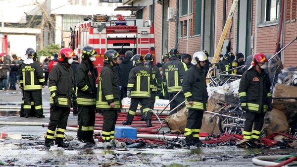 Firefighters inspect the area where a fire broke out in a Chinese-run garment factory in Prato, near Florence, Italy, Sunday, Dec. 1, 2013 - Sputnik International