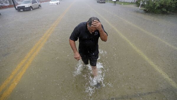Angel Marshman wades through floodwaters from Tropical Depression Imelda after trying to start his flooded car Wednesday, Sept. 18, 2019, in Galveston, Texas. (AP Photo/David J. Phillip) - Sputnik International