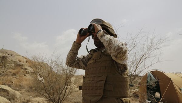 A Saudi soldier looks with binoculars toward the border with Yemen in Jazan, Saudi Arabia, Monday, April 20, 2015 - Sputnik International