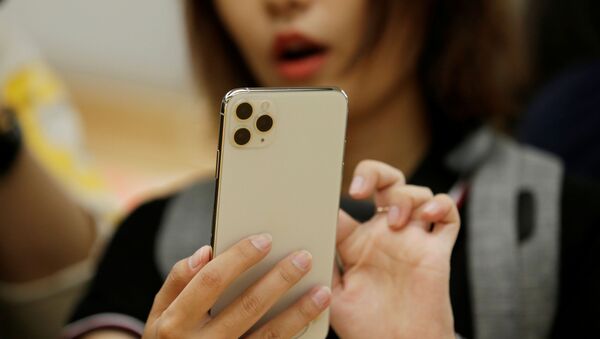 A woman holds an iPhone 11 Pro Max while giving a live broadcast after it went on sale at the Apple Store in Beijing, China, September 20, 2019 - Sputnik International