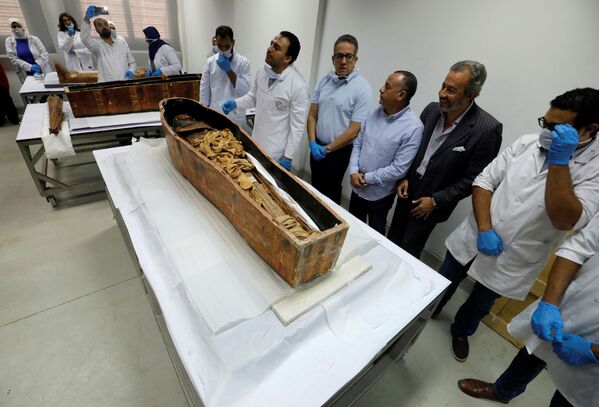 Egyptian Minister of Antiquities Khaled El-Enany (C) and archaeologists look at the pharaonic mummy of Sennedjem  after it was removed from his coffin at the National Museum of Egyptian Civilization in Cairo - Sputnik International