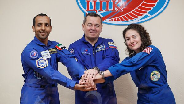 Crew members Jessica Meir of the US, Oleg Skripochka of Russia and Hazzaa Ali Almansoori of the United Arab Emirates pose for a picture behind a glass wall during a final news conference ahead of their mission to the International Space Station (ISS) in Baikonur, Kazakhstan, 24 September 2019. - Sputnik International