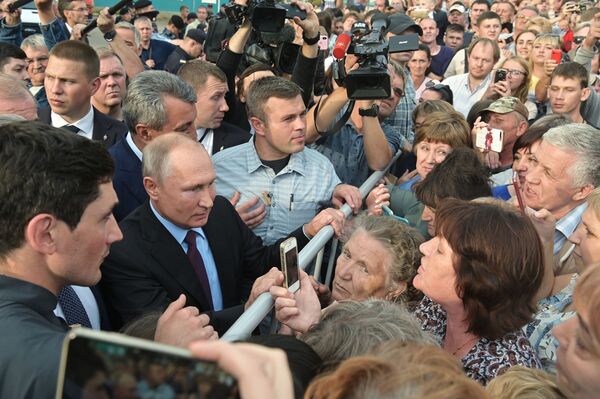 Russia's President Vladimir Putin talks to locals after visiting a school in the town of Tulun in eastern Siberia. - Sputnik International