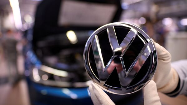 An employee holds a Volkswagen logo in a production line at the Volkswagen plant in Wolfsburg, Germany March 1, 2019 - Sputnik International