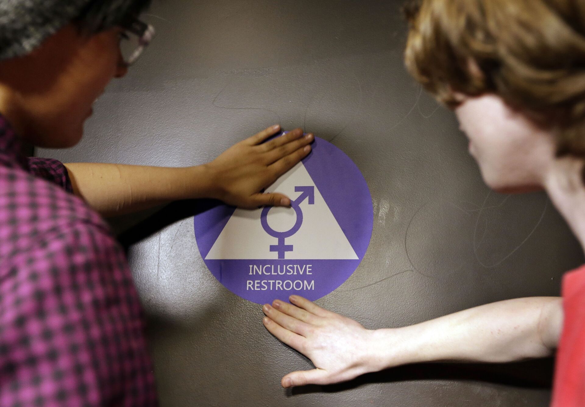 Destin Cramer, left, and Noah Rice place a new sticker on the door at the ceremonial opening of a gender neutral bathroom at Nathan Hale high school Tuesday, May 17, 2016, in Seattle - Sputnik International, 1920, 28.07.2023