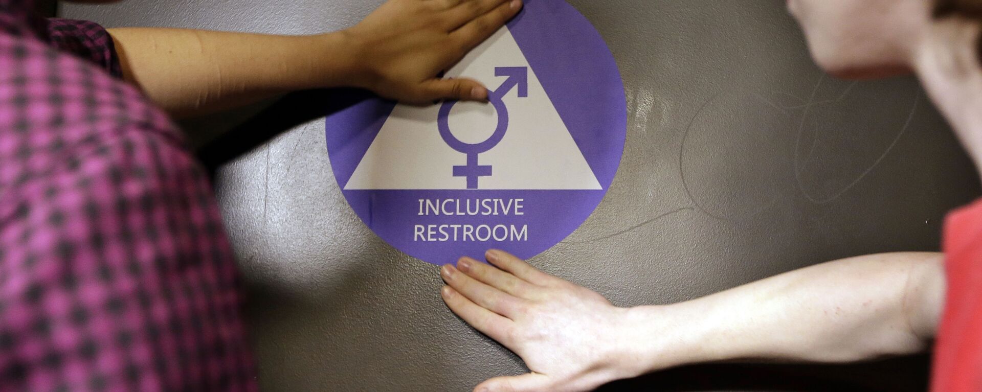 Destin Cramer, left, and Noah Rice place a new sticker on the door at the ceremonial opening of a gender neutral bathroom at Nathan Hale high school Tuesday, May 17, 2016, in Seattle - Sputnik International, 1920, 14.10.2022