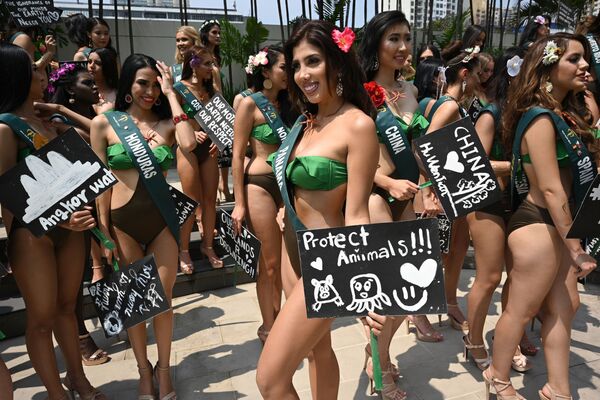 Miss Earth candidate Marrianna Fuentes (C) of Panama holds a placard with an environment theme as she poses with other Miss Earth candidates for photos during a press presentation at a hotel in Manila on October 2, 2019.  - Sputnik International