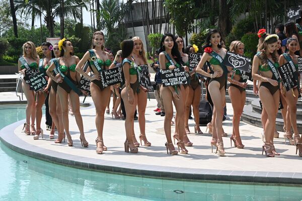 Miss Earth candidates holding placards with environmental slogans pose for photos during a press presentation at a hotel in Manila on October 2, 2019. - Sputnik International