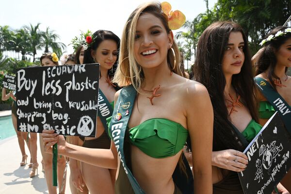 Miss Earth candidate Antonela Paz of Ecuador (C) holds a placard with an environment theme as she poses with other Miss Earth candidates for photos during a press presentation at a hotel in Manila on October 2, 2019. - Sputnik International