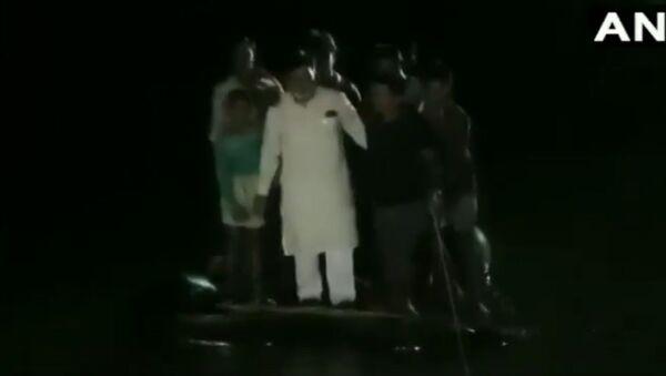 BJP MP Ram Kripal Yadav falls into the water after the makeshift boat he was in, capsized in Masaurhi, Patna district, during his visit to the flood affected areas yesterday - Sputnik International