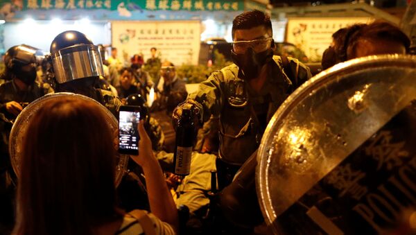 A police officer holds a bottle of peper spray against protesters at a demonstration at Taikoo station in Hong Kong, China October 3, 2019 - Sputnik International