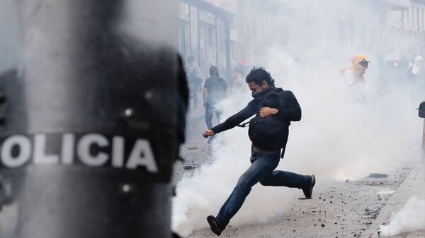 A demonstrator runs to kick a tear gas canister after clashes with the police erupted during a protest against elimination of fuel subsidies announced by President Lenin Moreno, in Quito, Ecuador, Thursday, Oct. 3, 2019.  - Sputnik International