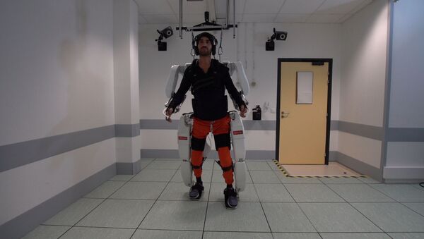 A patient with tetraplegia walks using an exoskeleton in Grenoble, France, in February 2019 - Sputnik International