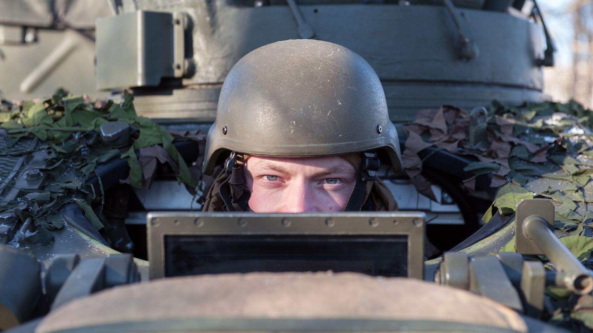 A soldier looking out of the British armed reconnaissance vehicle FV107 SCIMITAR during a NATO demonstration of military vehicles and weapons in Latvia. - Sputnik International, 1920, 20.02.2021
