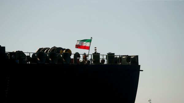 A crew member raises the Iranian flag at Iranian oil tanker Adrian Darya 1, formerly named Grace 1, as it sits anchored after the Supreme Court of the British territory lifted its detention order, in the Strait of Gibraltar, Spain, August 18, 2019. - Sputnik International