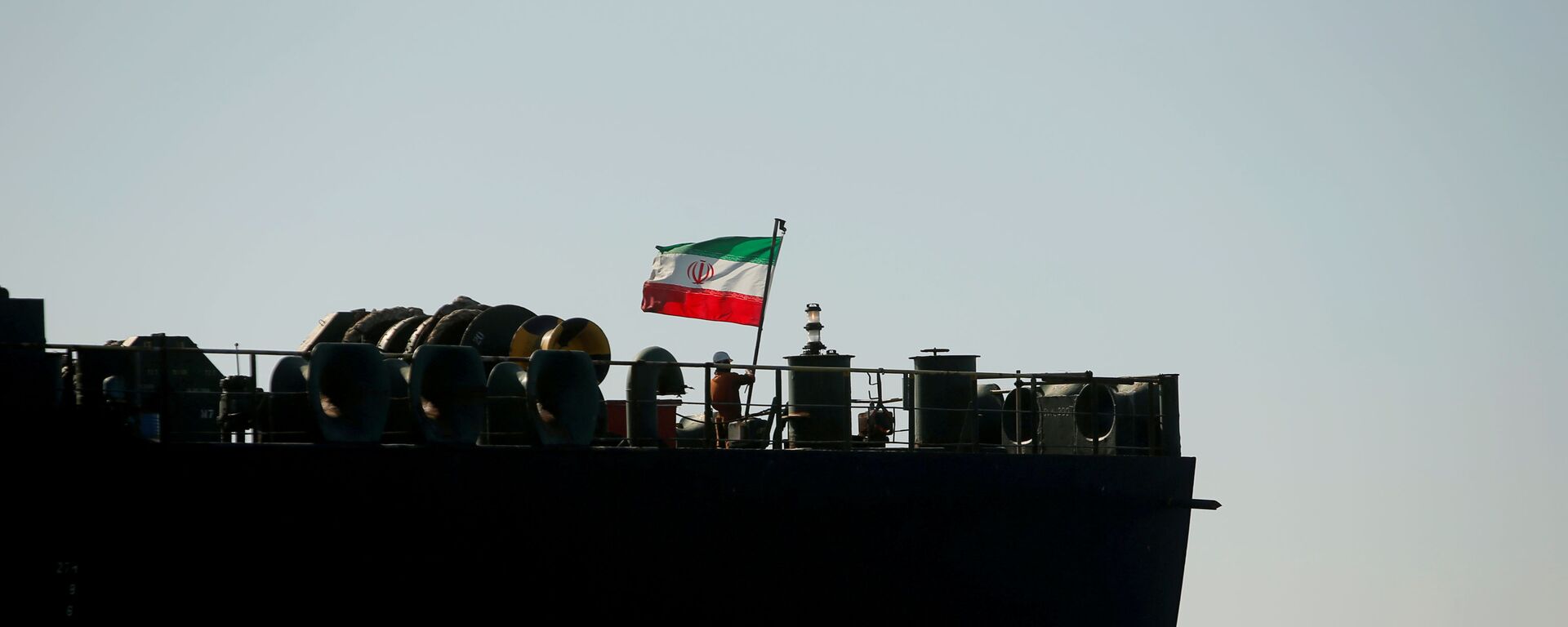 A crew member raises the Iranian flag at Iranian oil tanker Adrian Darya 1, formerly named Grace 1, as it sits anchored after the Supreme Court of the British territory lifted its detention order, in the Strait of Gibraltar, Spain, August 18, 2019. - Sputnik International, 1920, 04.01.2022