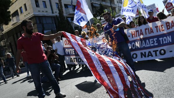 Protesters burn a U.S. flag during a demonstration against the visit of U.S. Secretary of State Mike Pompeo, in central Athens, Saturday, Oct. 5, 2019.  - Sputnik International