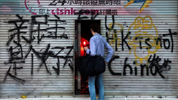 A man stands in front of a shop destroyed by anti-government protesters during a demonstration in Wan Chai district, in Hong Kong, China October 6, 2019 - Sputnik International