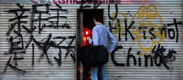 A man stands in front of a shop destroyed by anti-government protesters during a demonstration in Wan Chai district, in Hong Kong, China October 6, 2019 A man stands in front of a shop destroyed by anti-government protesters during a demonstration in Wan Chai district, in Hong Kong, China October 6, 2019 - Sputnik International