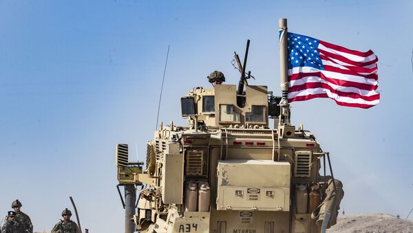 A US soldier sits atop an armoured vehicle  - Sputnik International