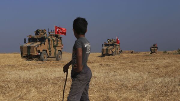 A Turkish n armored vehicles patrol as they conduct a joint ground patrol with American forces in the so-called safe zone on the Syrian side of the border with Turkey, near the town of Tal Abyad, northeastern Syria, Friday, Oct.4, 2019 - Sputnik International
