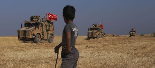 A Turkish n armored vehicles patrol as they conduct a joint ground patrol with American forces in the so-called safe zone on the Syrian side of the border with Turkey, near the town of Tal Abyad, northeastern Syria, Friday, Oct.4, 2019 - Sputnik International