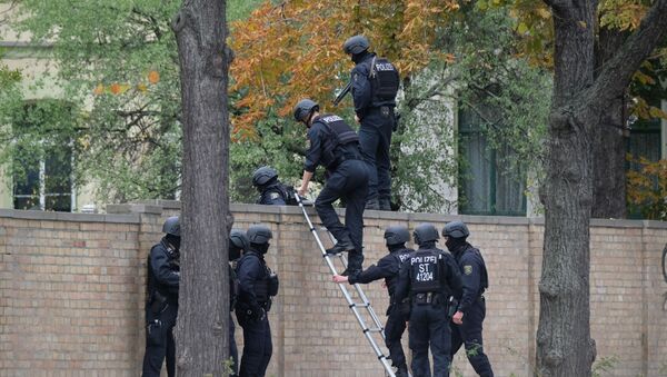 Police officers cross a wall at a crime scene in Halle, Germany, Wednesday, Oct. 9, 2019 - Sputnik International