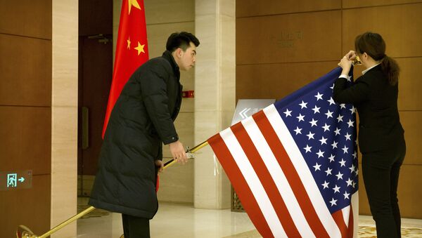 Chinese staffers adjust a US flag before the opening session of trade negotiations between the US and Chinese trade representatives at the Diaoyutai State Guesthouse in Beijing, 14 February 2019 - Sputnik International