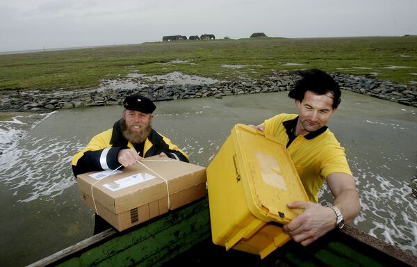 Germany's most northerly post skipper Fiede Nissen, left, and his colleague Andreas Oberauer who is said to be Germany's most northerly postman bring packages and letters to the residents of the tiny island of Groede in the North Sea on Tuesday, Dec.5, 2006.  - Sputnik International
