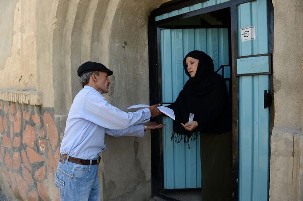 In this photograph taken on June 11, 2013, Afghan postman Mohammad Rahim delivers letters to a resident in the Kart-e-Sakhi neighbourhood of Kabul. - Sputnik International
