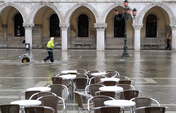 A postman crosses the flooded Saint-Mark's Square in Venice on November 3, 2009. - Sputnik International