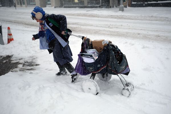 A postwoman drags her mail cart on a snow-covered street during a winter storm in New York on February 9, 2017.  - Sputnik International