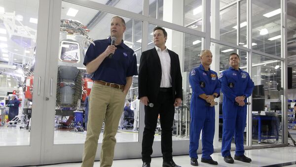 NASA Administrator Jim Bridenstine, left, talks with SpaceX chief engineer Elon Musk, second from left, and NASA astronauts crew Doug Hurley and Bob Behnken, right, in front of the Crew Dragon spacecraft, about the progress to fly astronauts to and from the International Space Station, from American soil, as part of the agency's commercial crew program at SpaceX headquarters, in Hawthorne, Calif., Thursday, Oct. 10, 2019 - Sputnik International