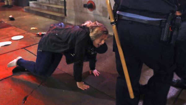 A woman is knocked to the ground after a rally by U.S. President Donald Trump in Minneapolis, Minnesota, U.S. October 10, 2019 - Sputnik International