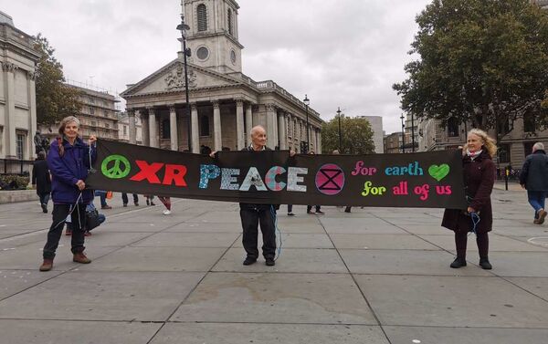 Activists from the Extinction Rebellion (XR) Peace group pose with a banner near the National Gallery at Trafalgar Square in London, UK on 11 October 2019 - Sputnik International